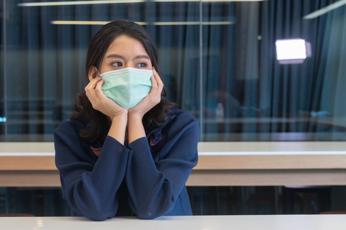 young asian women in being sick wearing protective mask virus germs,  sitting in office, wearing hygienic mask prevents infection during the outbreak of virus covid-19.